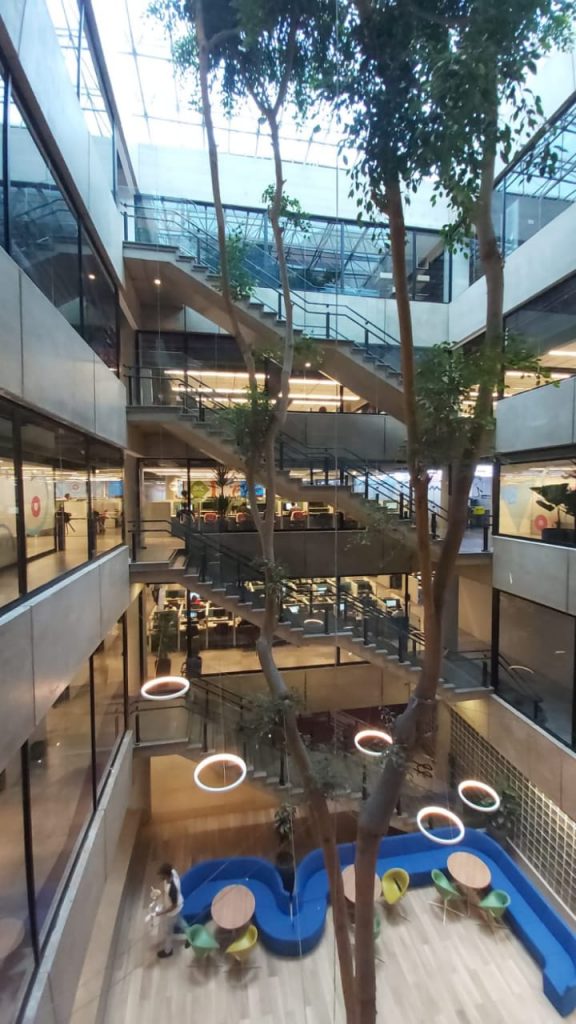 Imagem do alto do site da AeC Em SP, mostrando a árvore central e o ambiente amigável